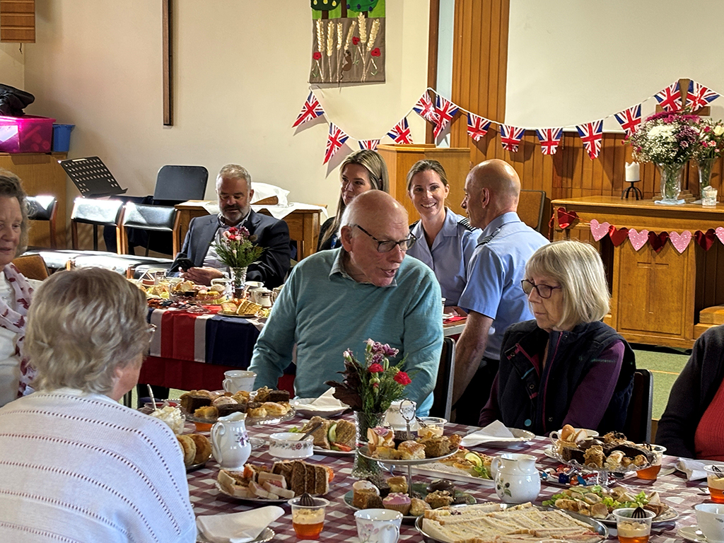 A view of local residents sitting at one of the tables chatting and enjoying lunch